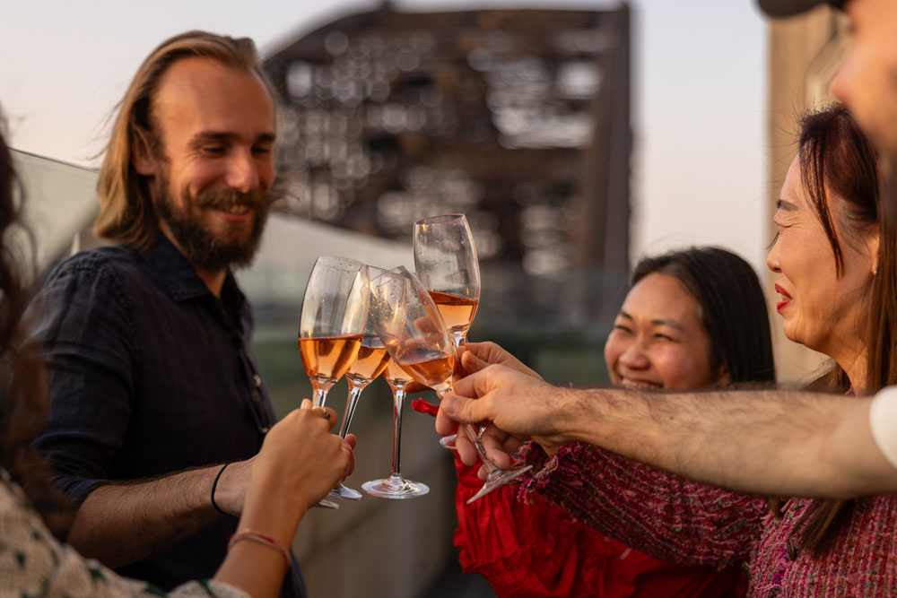 a group of people clinking wine glasses