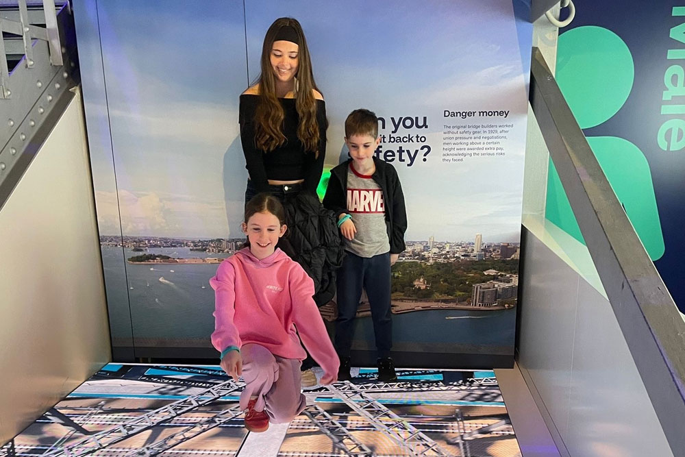 three children enjoying the balance beam exhibit at the bridgemuseum