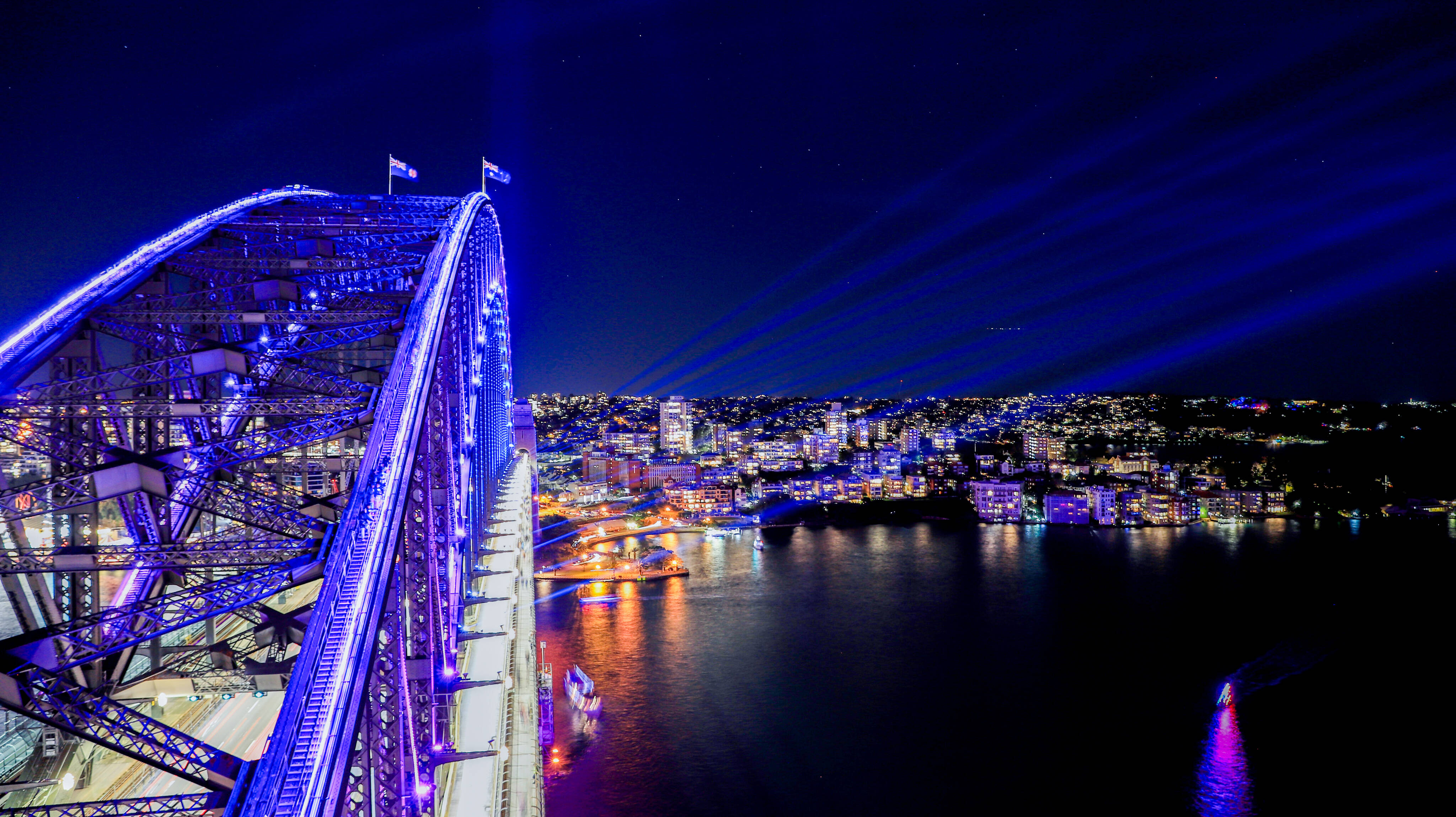 a bridge with lights and a city in the background